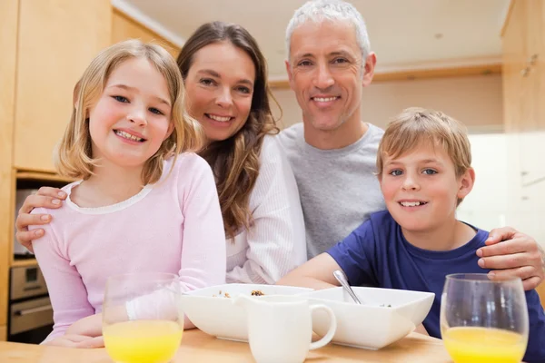 Primer plano de una familia sonriente desayunando — Foto de Stock