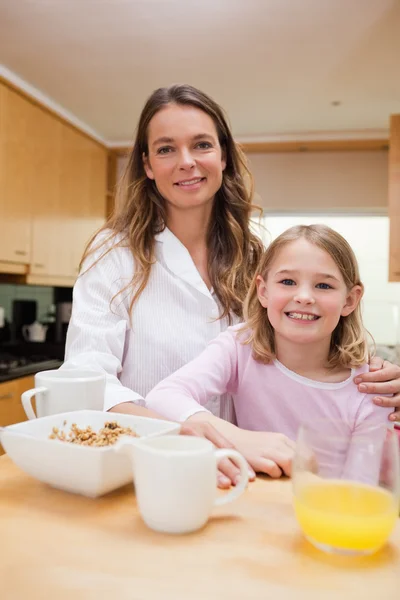 Portrait of a mother and her daughter having breakfast — Stock Photo, Image