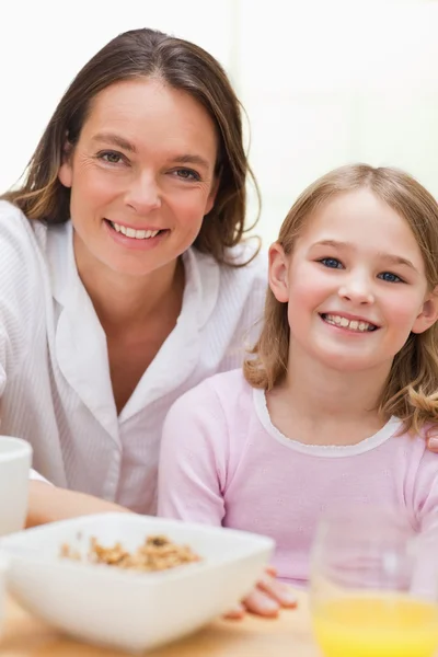 Retrato de uma mãe adorável e sua filha tomando café da manhã — Fotografia de Stock