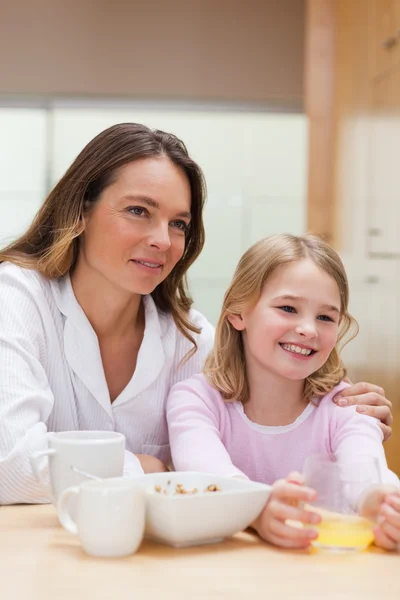 Portrait of a beautiful mother and her daughter having breakfast — Stock Photo, Image