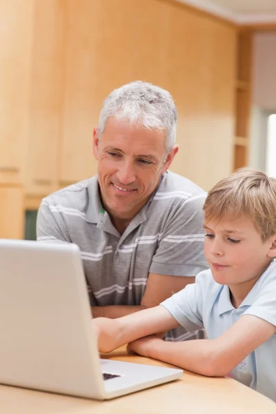 Porträtt av en pojke och hans far som använder en bärbar dator — Stockfoto