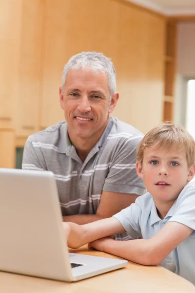 一个男孩和他的父亲使用的便携式计算机的肖像 — 图库照片
