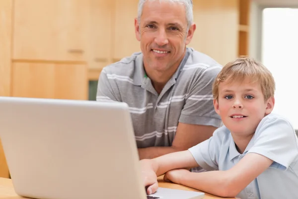 Fiatal fiú és az apja, használ egy laptop — Stock Fotó