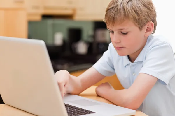 Chłopiec koncentruje się za pomocą laptopa — Zdjęcie stockowe