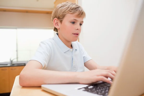 Menino loiro usando um laptop — Fotografia de Stock