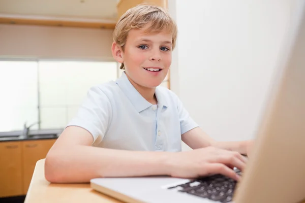 Blond boy använder en bärbar dator — Stockfoto