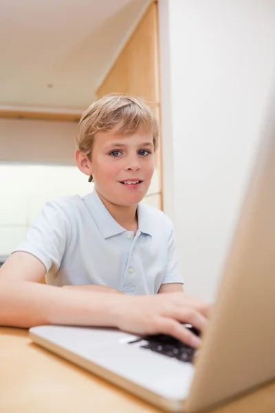 Bir dizüstü bilgisayar kullanarak bir sarışın çocuk portresi — Stok fotoğraf