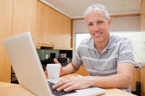 Mann benutzt beim Teetrinken ein Notizbuch — Stockfoto