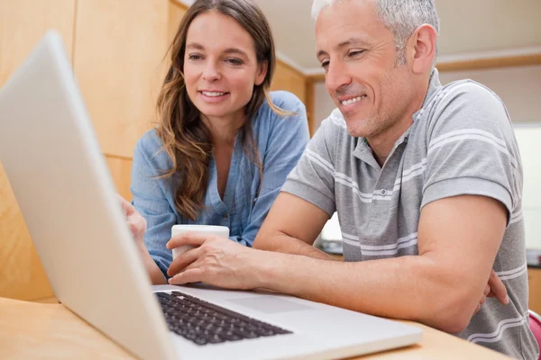 Couple using a laptop while having coffee — Stock Photo, Image