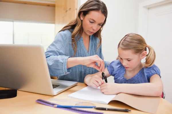 Mulher ajudando sua filha fazendo seu dever de casa — Fotografia de Stock