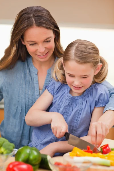 Portrait of a mother slicing bell pepper with her daughter — Stock Photo, Image