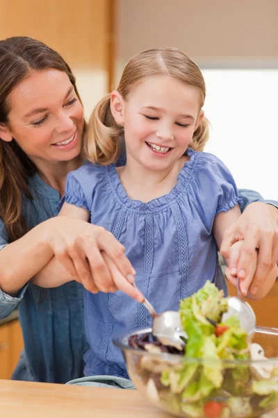 Retrato de uma mãe preparando uma salada com sua filha — Fotografia de Stock