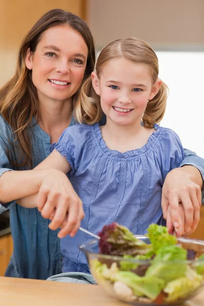 Πορτρέτο του μια ευτυχισμένη μητέρα ετοιμάζει μια σαλάτα με την κόρη της — Φωτογραφία Αρχείου