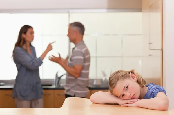 Грустная маленькая девочка слушает, как ее родители ссорятся — стоковое фото