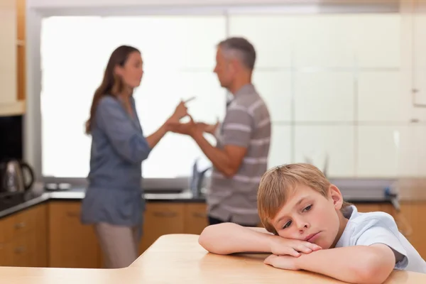 Üzgün küçük çocuk ailesi savunarak işitme — Stok fotoğraf