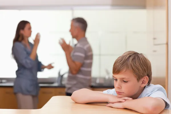 Triste niño escuchando a sus padres teniendo una discusión —  Fotos de Stock
