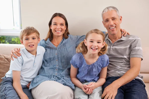 Familjen sitter på en soffa — Stockfoto