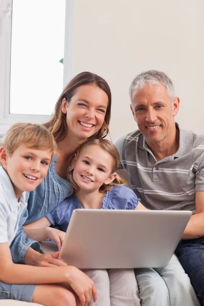 Portret rodziny siedzi na kanapie przy pomocy pewien laptop — Zdjęcie stockowe