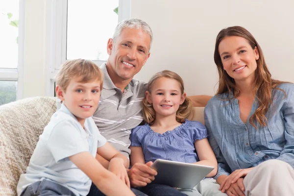 Усміхнена сім'я за допомогою планшетного комп'ютера — стокове фото