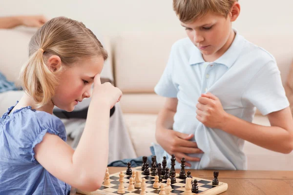 Братья и сестры играют в шахматы — стоковое фото