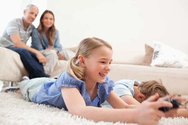 艾菲尔铁塔的背景上玩电子游戏与他们的父母的儿童 — 图库照片