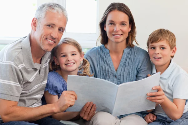 Lezen van een boek samen en gelukkige familie — Stockfoto