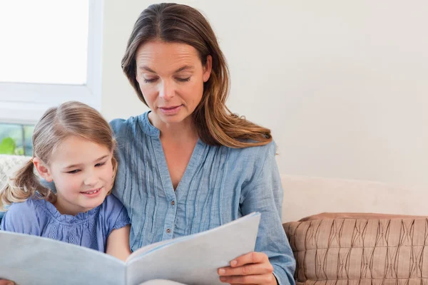 Mamma läser en bok till sin dotter — Stockfoto