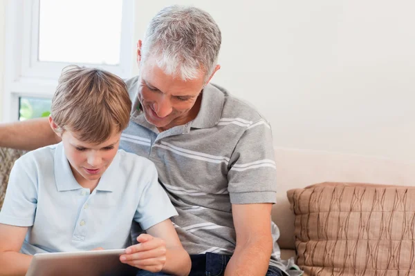 Far och hans son som använder en tablet-dator — Stockfoto