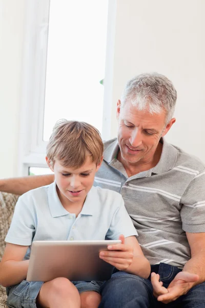 一位父亲和他的儿子使用一款平板电脑的肖像 — 图库照片