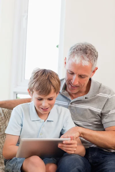 Porträt eines glücklichen Vaters und seines Sohnes mit einem Tablet-Computer — Stockfoto