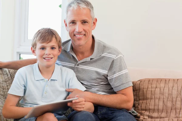 微笑的父亲和他的儿子使用一台平板电脑 — 图库照片