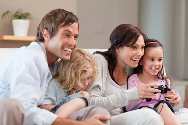 Família encantada jogando jogos de vídeo juntos — Fotografia de Stock