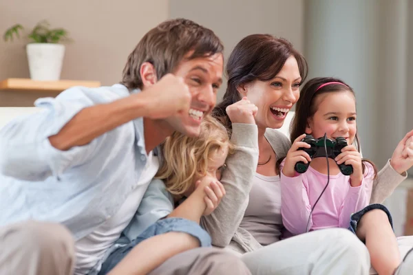 Familia positiva jugando videojuegos juntos — Foto de Stock