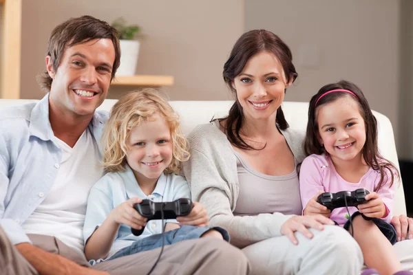 Lächelnde Familie, die gemeinsam Videospiele spielt — Stockfoto