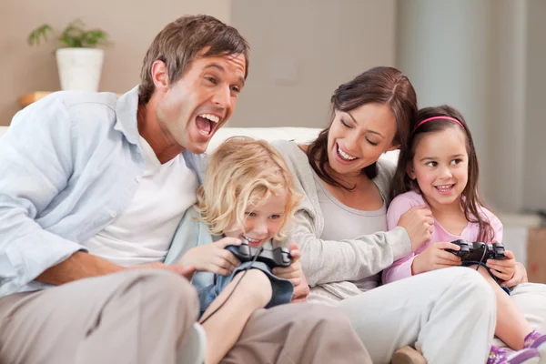 Família rindo jogando videogames — Fotografia de Stock