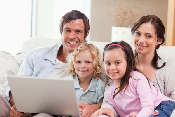 Famille enchantée utilisant un ordinateur portable — Photo
