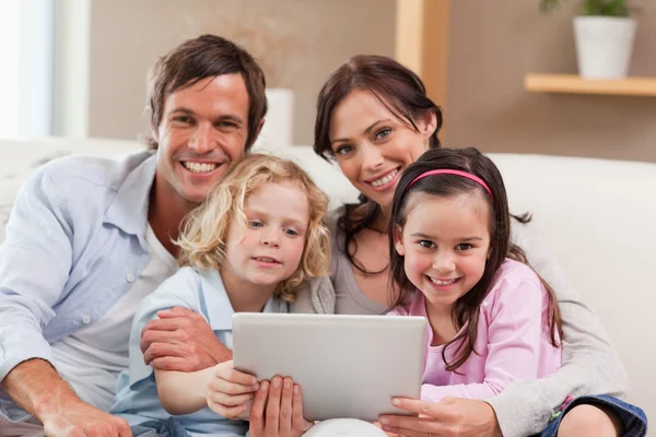Família encantadora usando um computador tablet — Fotografia de Stock