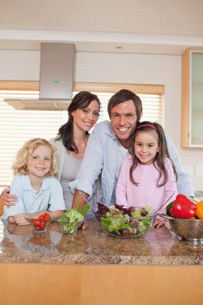 Retrato de uma família preparando uma salada — Fotografia de Stock