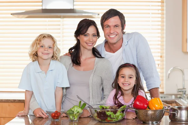 Family preparing a salad together — Stock Photo, Image