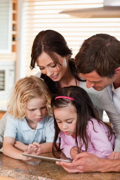 Portrait of a happy family using a tablet computer together — Stock Photo, Image