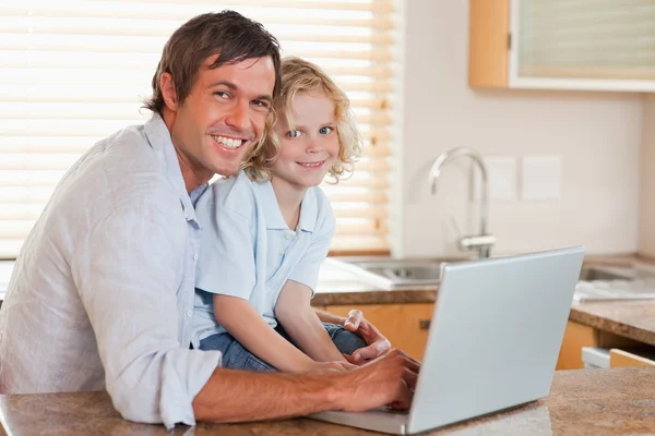 Boy and his father using a notebook together — Stock Photo, Image