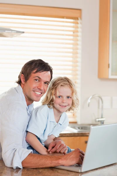 Portrait of a boy and his father using a notebook together — Stock Photo, Image