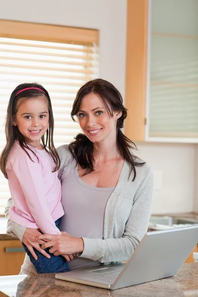 Portrait of a girl and her mother using a notebook — Stock Photo, Image