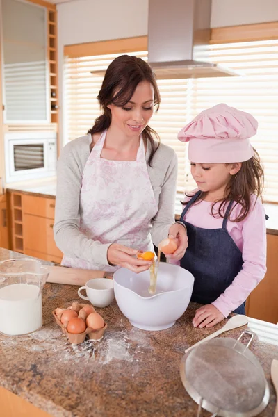 Portrait of a happy mother and her daughter baking — Stock Photo, Image