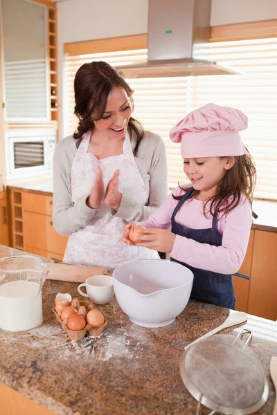 一位母亲教她的女儿如何烤的肖像 — 图库照片