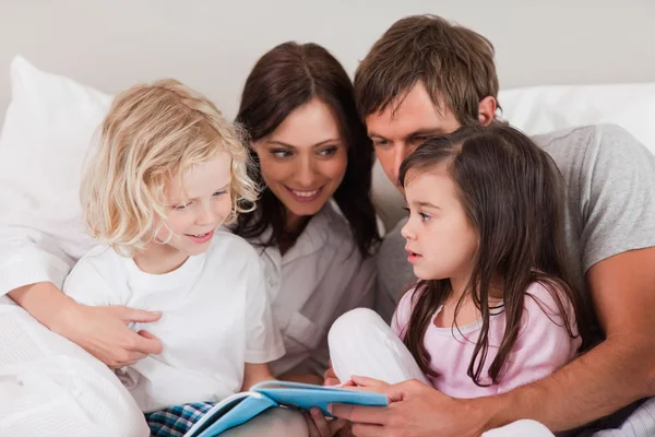 Familie die een boek leest — Stockfoto