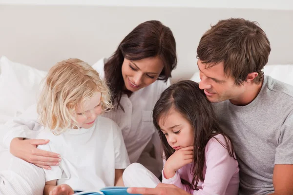 Underbara familj läser en bok — Stockfoto