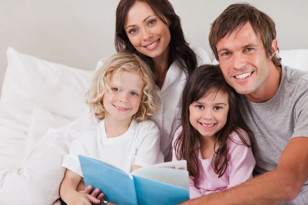 Happy family reading a book — Stock Photo, Image