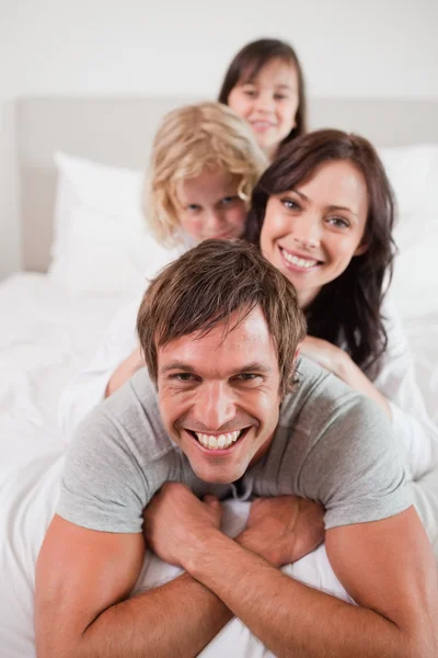 Portret van een speelse familie liggend op elkaar — Stockfoto