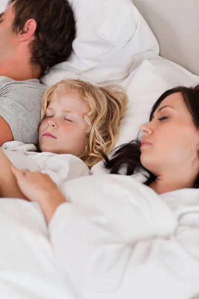 Porträtt av en pojke sov mellan föräldrarna — Stockfoto